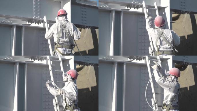 穿着防护服的工人在建筑工上涂白色涂料