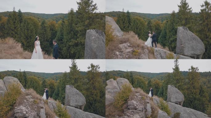 新婚夫妇站在山的高坡上。