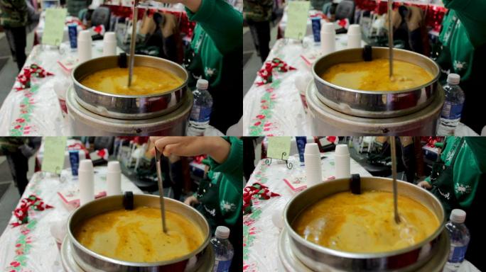 在圣诞节庆祝活动中搅拌咖喱汤
