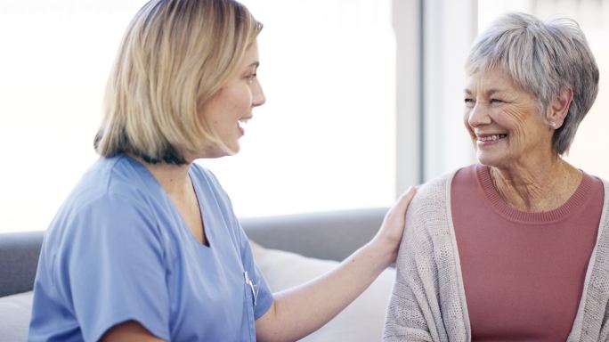 一名年轻女护士在养老院与老年患者交谈