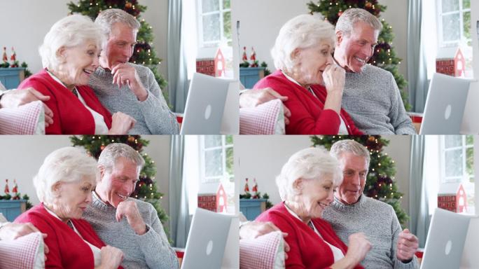 老年夫妇用笔记本电脑给家人打圣诞视频电话