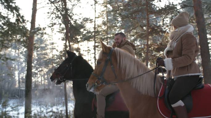 情侣在雪林中骑马冬季雪原大雪冬至森林树林