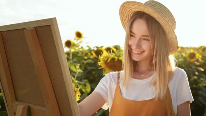 女人站在向日葵地里画画