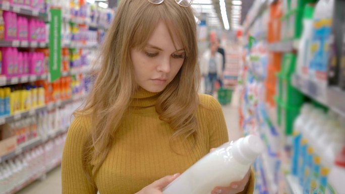 年轻女性在超市选购洗衣液