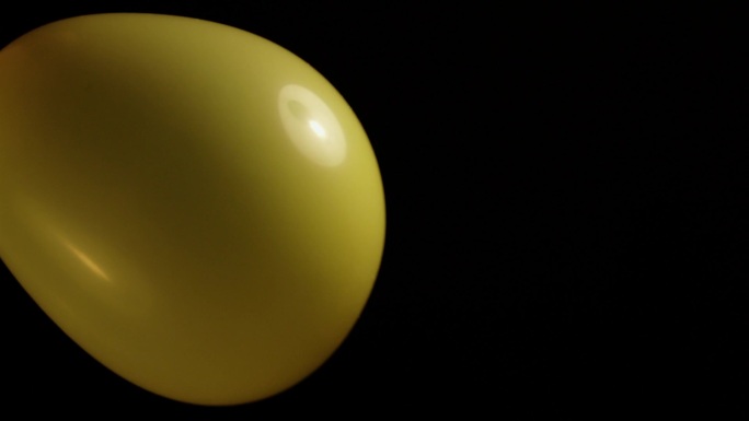 黄色气球在黑暗的背景下膨胀