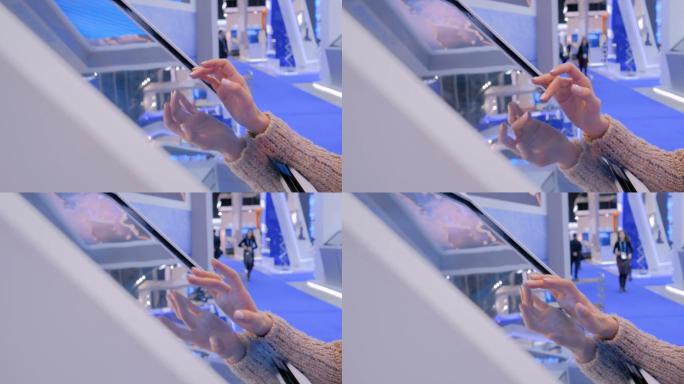 在科技展上使用交互式触摸屏的女性
