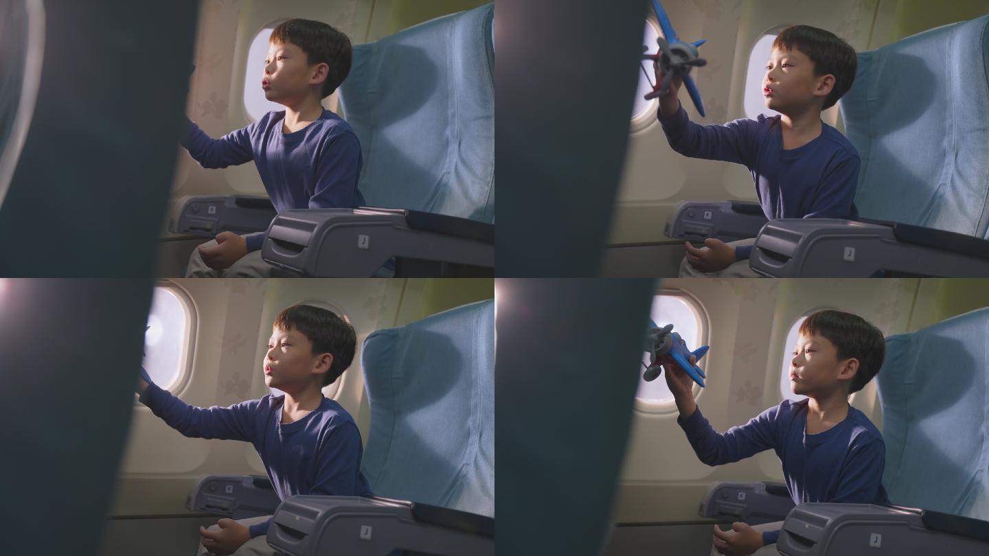 小男孩坐在飞机上玩飞机模型玩具