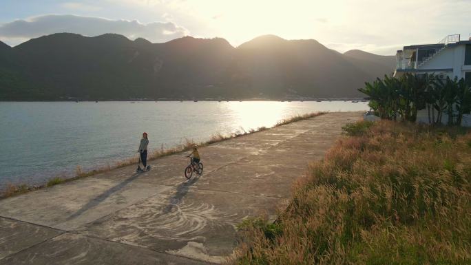 女子和她的儿子在海边骑脚踏车