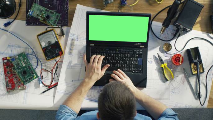 技术人员在绿色屏幕笔记本电脑上打字