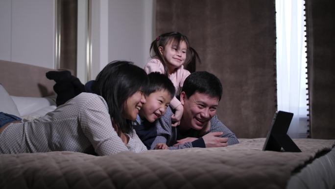 在平板电脑上看喜剧的亚洲家庭
