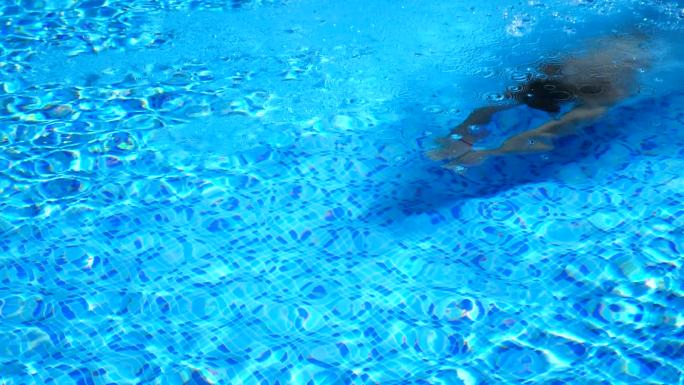 男人在酒店游泳池的水下游泳