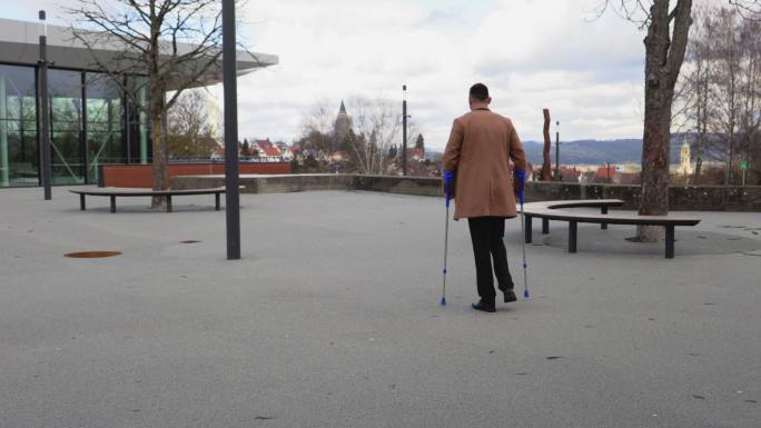 男人拄着拐杖散步公园湿地景区旅游风光河流