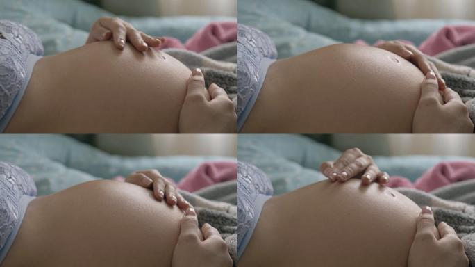 孕妇抚摸她的腹部