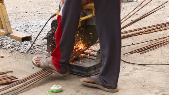 一名工人在建筑工地用切割机切割钢筋