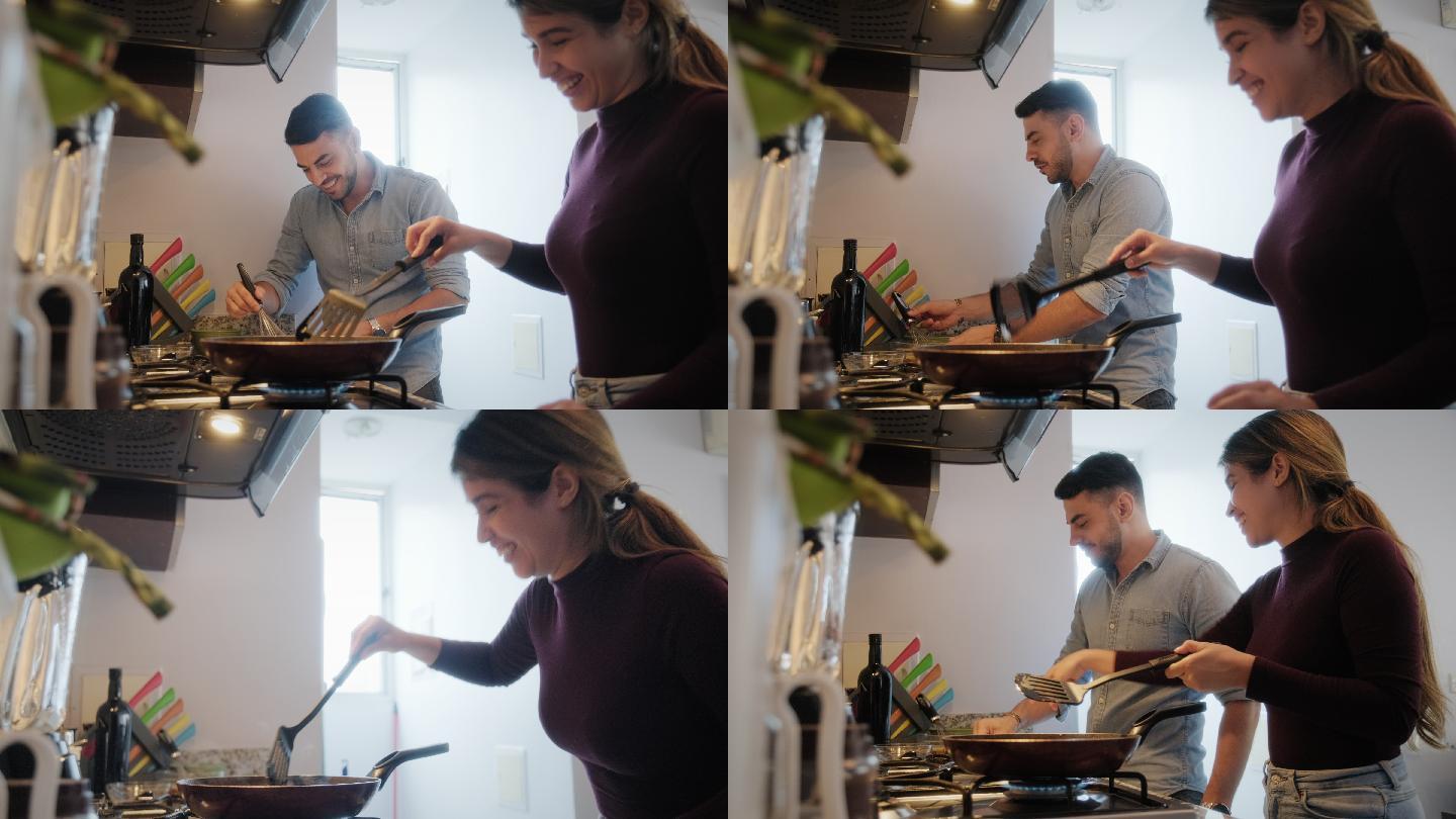 幸福的夫妇在厨房做饭时大笑