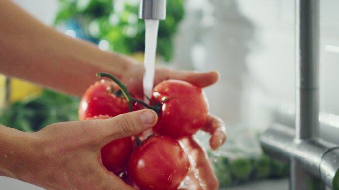 用自来水清洗西红柿的慢镜头特写镜头