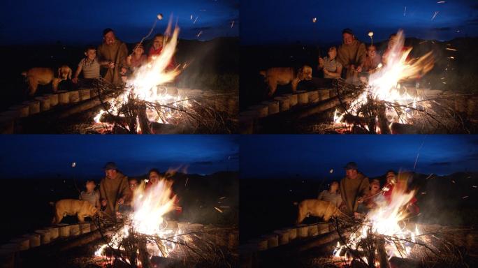 在篝火上烤棉花糖户外烧烤聚餐生火野外露营