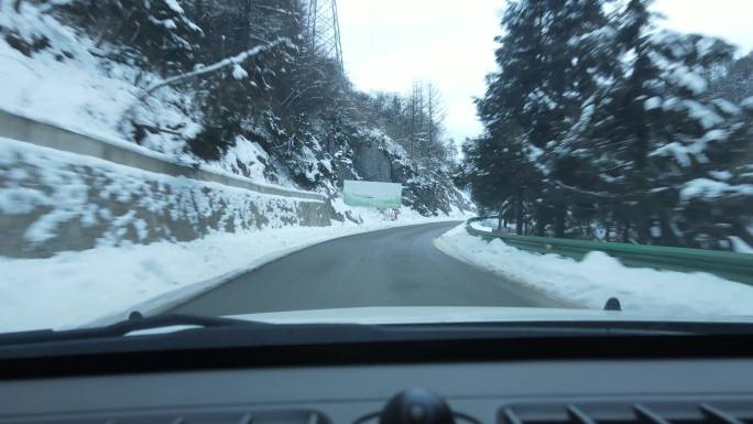 开车行驶在雪山公路上
