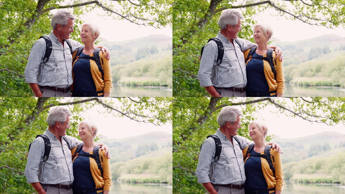 湖区一对老年夫妇沿着河边散步的慢镜头照片