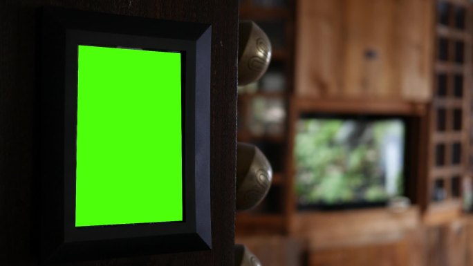 客厅柱子上挂着绿色屏幕相框，背景是电视