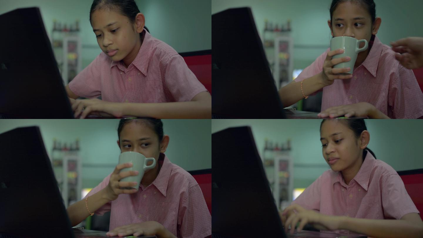 小女孩用笔记本电脑做作业