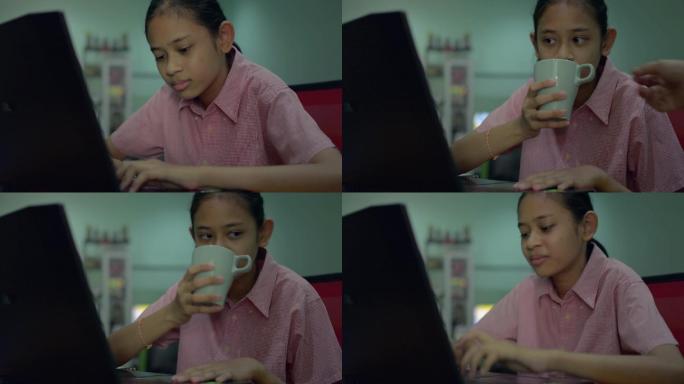 小女孩用笔记本电脑做作业