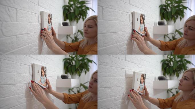 年轻女子把照片放在墙壁上装饰客厅