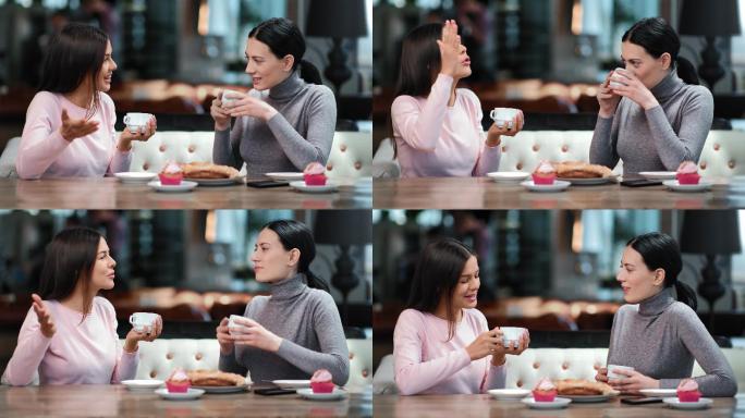 两位微笑的女性朋友在咖啡馆边喝茶边吃甜点