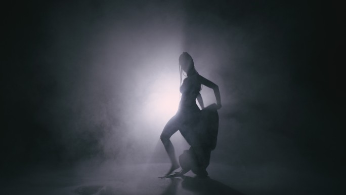 剪影舞女在雾中表演舞蹈