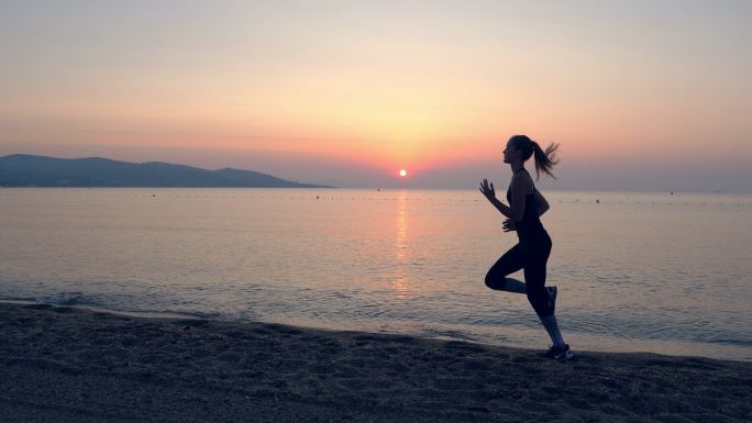 年轻女子在海边慢跑的身影