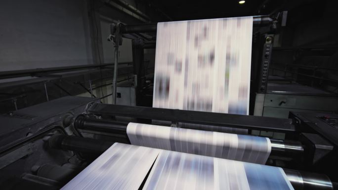 CS印刷厂的机器正在将报纸切成页