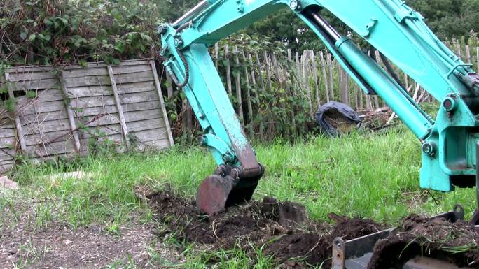 小型挖掘机在家庭花园中挖土