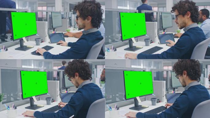 经理在带有绿色屏幕模型的台式电脑上工作。