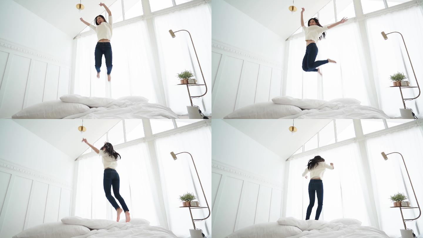 女性在卧室的白色床上跳跃的慢动作