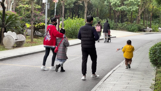 一家四口三孩主力军在儿童公园里散步踏青
