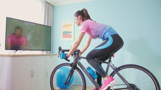 女子骑健身自行车运动健身骑行运动