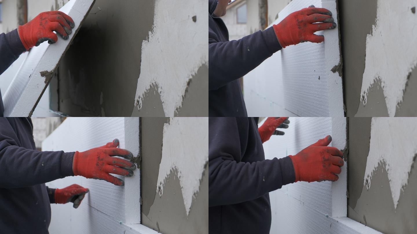 建筑工人在房屋外墙上安装泡沫塑料隔热板