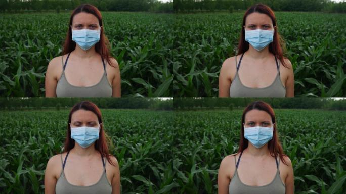 在玉米地里戴着医用口罩的农妇。