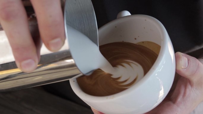 在特写镜头中制作拿铁的咖啡师