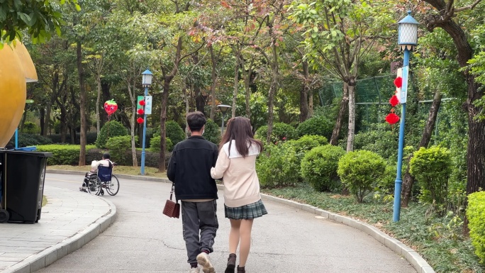 热恋中情侣在公园健康步道上散步踏青