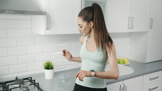 女性锻炼后在厨房喝水