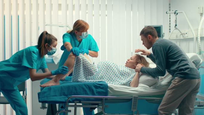 在医院分娩的妇女，丈夫握着她的手