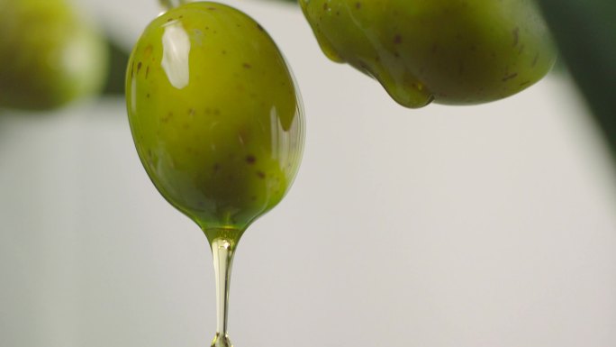 滴在生绿橄榄上的橄榄油。