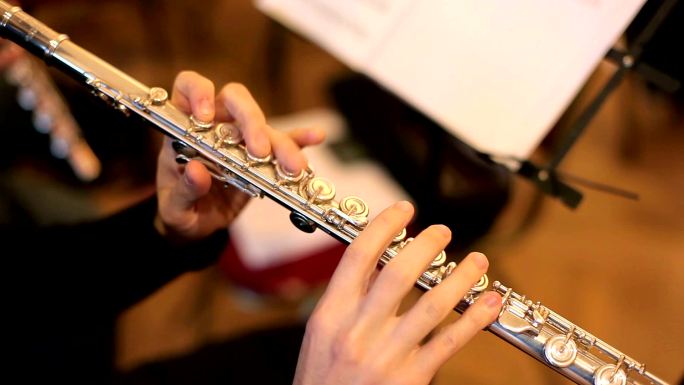 音乐家吹长笛。木管乐器人手银金属