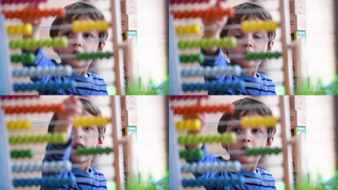 小男孩在幼儿园学习使用彩色算盘数数