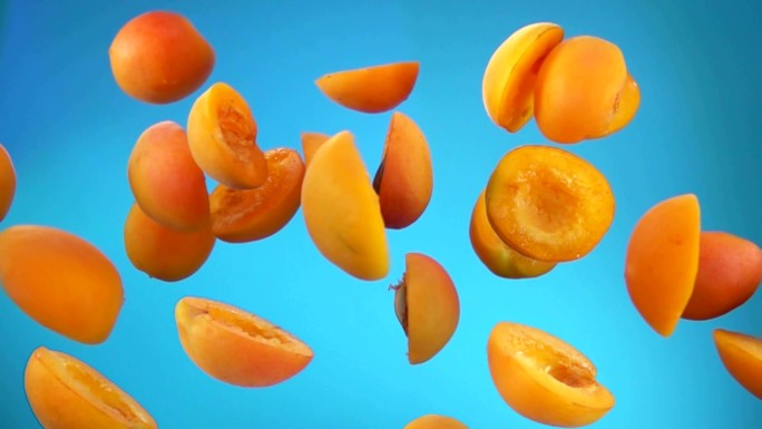 多汁的杏瓣在蓝色背景上反弹