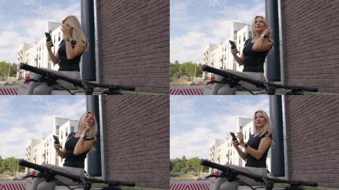 骑自行车后使用手机的运动型女性