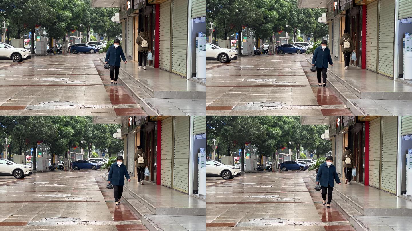 清晨雨后买菜的老年妇女走在大街上