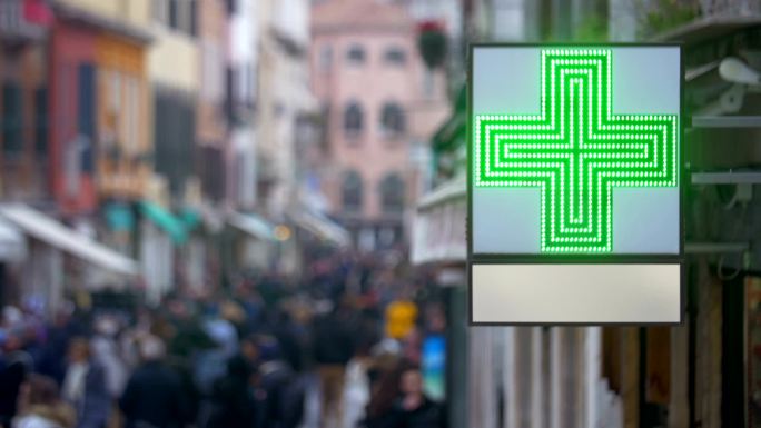 繁忙街道上有绿十字标志的药房