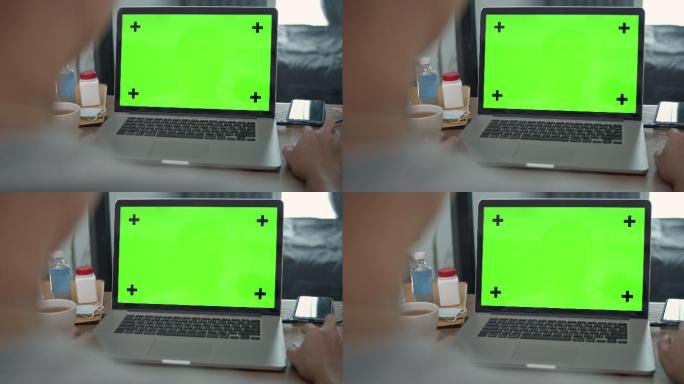 男子正在使用绿色屏幕的笔记本电脑